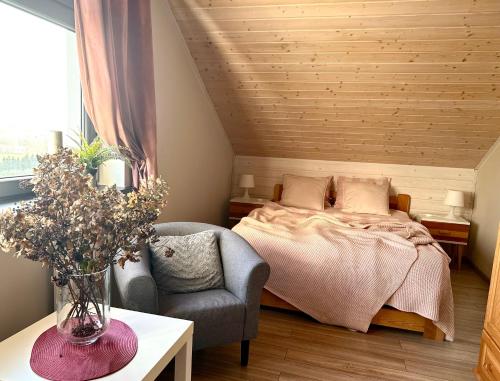 - une chambre avec un lit et une chaise dans l'établissement AHOY - Haus am Meer, à Chłopy