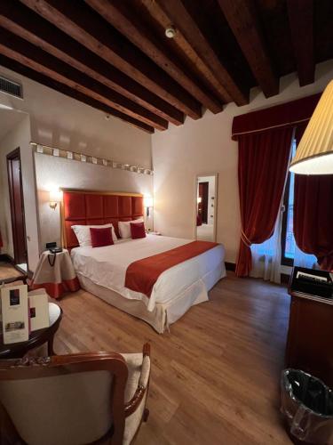 a bedroom with a large bed with a red headboard at Ruzzini Palace Hotel in Venice