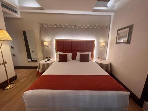 a bedroom with a large bed with two tables at Ruzzini Palace Hotel in Venice