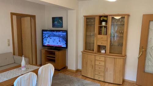 ein Wohnzimmer mit einem TV und einem Entertainment-Center in der Unterkunft Apartment close to the center + free parking in Oldenburg