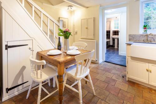 a kitchen and dining room with a wooden table and chairs at Sunny Beck Cottage - Norfolk Cottage Agency in Mundesley