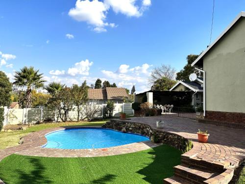 a swimming pool in the yard of a house at The Valley, tranquil 3 bedroom home with pool in Midrand
