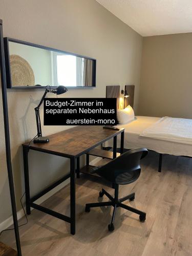 a desk in a room with a bed and a desk chair at AUERSTEIN-Hotels auerstein & auerstein-mono in Heidelberg