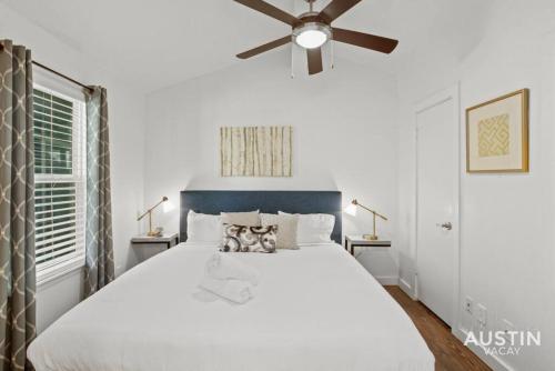a bedroom with a large white bed with a ceiling fan at 5 Minutes to Zilker Barton Springs with Parking in Austin