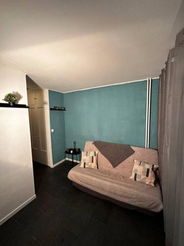 um quarto com uma cama e uma parede azul em Superbe studio avec piscine ext em Antibes