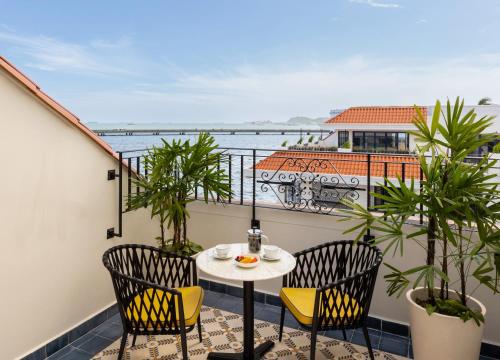 a balcony with a table and chairs and the ocean at Sofitel Legend Casco Viejo, Panama City in Panama City