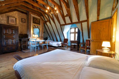 Un dormitorio con una cama grande en una habitación con techos de madera. en Manoir de la Maison Blanche en Amboise