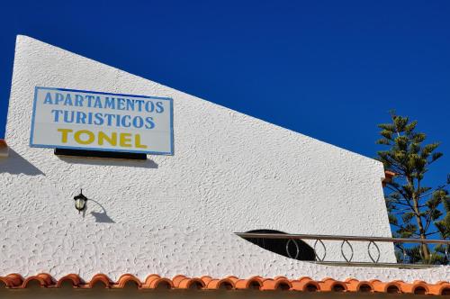 a sign on the side of a white building at Tonel Apartamentos Turisticos in Sagres