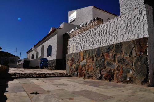 a stone wall in front of a building at Tonel Apartamentos Turisticos in Sagres