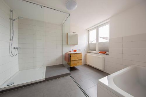 ein Badezimmer mit Dusche, Badewanne und Waschbecken in der Unterkunft Hotel & Boarding House Schlosserwirt in Mering
