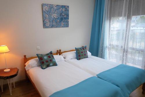 a bedroom with a large white bed with a window at Apartamento Calle San Isidro 1ºA in Ezcaray