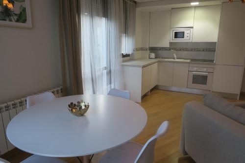 una mesa blanca y sillas en la sala de estar. en Apartamento Calle San Isidro 1ºA, en Ezcaray