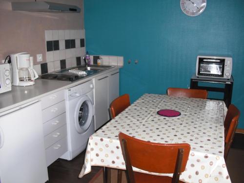 - une cuisine avec une table et un lave-linge dans l'établissement alc09, à Celles
