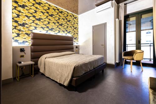 - une chambre avec un lit et un mur jaune dans l'établissement Hotel Dei Nani, à Jesi