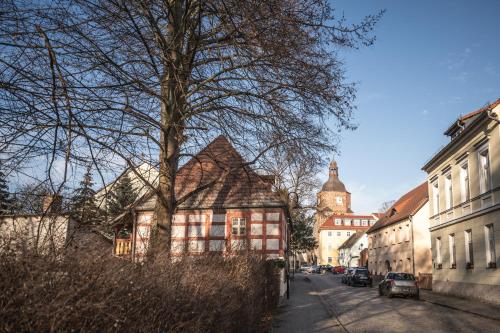 a building on a street with a tree and buildings at Helene in Vetschau