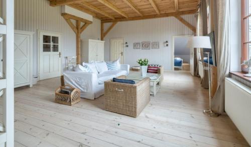 a living room with a white couch and a table at Ciekocinko Powozownia in Ciekocinko