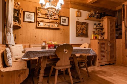a kitchen with a large wooden table and a chair at SciliarGuestHouse-due piani parcheggio privato in Castelrotto
