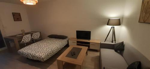 a room with a bed and a desk with a television at Sandy's 2 beds apartment Calme Parking Tramway in Blagnac