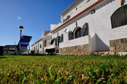 a building with a grassy yard in front of it at Tonel Apartamentos Turisticos in Sagres
