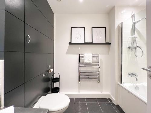 een witte badkamer met een toilet en een wastafel bij Lovely 2 Bed Duplex Apartment with Hydro Views in Glasgow