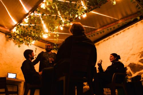 um grupo de pessoas sentadas à volta de uma mesa numa sala em Celaví Hostel em Monguí