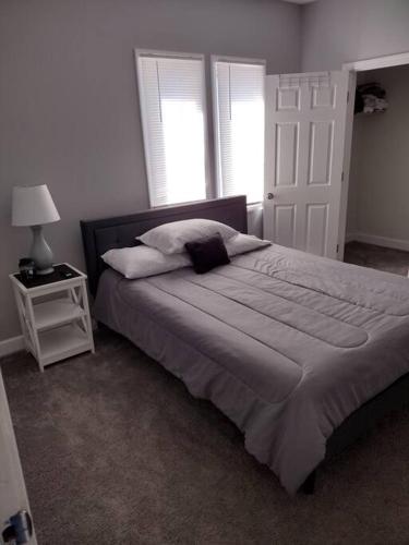 a bedroom with a large bed and two windows at Modern home on city's westside in Bay City
