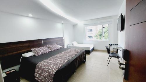 1 dormitorio con 1 cama, 1 silla y 1 ventana en Hotel Mediterraneo, en Medellín