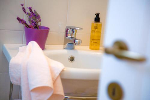a bathroom sink with a towel and a vase of flowers at VILLA EVA in Sirolo