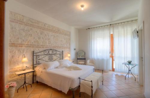 a bedroom with a white bed and a wall at VILLA EVA in Sirolo