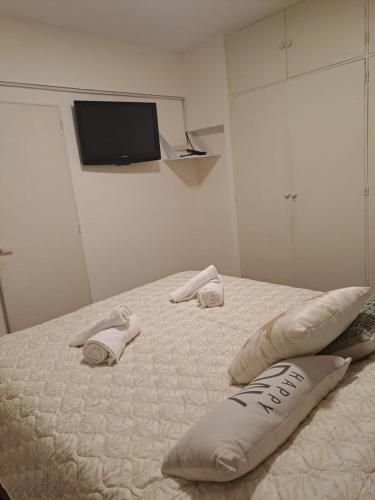 a bedroom with a bed with two pillows and a tv at Obelisco in Buenos Aires