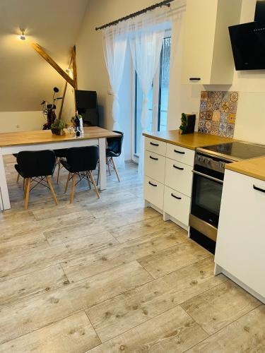 a kitchen with a wooden floor and a table with chairs at Apartamenty Happy & Relax in Bielsko-Biala