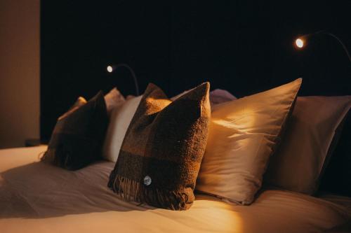 Una cama con cuatro almohadas encima. en SeaBeds - Luxury Lookouts with Hot Tubs en Glencoe