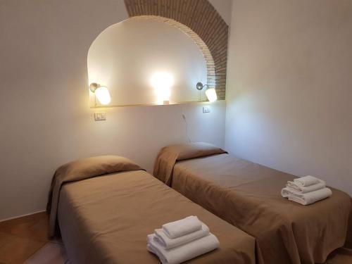 two beds in a room with a mirror and towels at Gulliver's Lodge in Rome