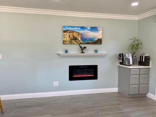 a living room with a fireplace and a painting on the wall at Aura Inn Monterey in Monterey