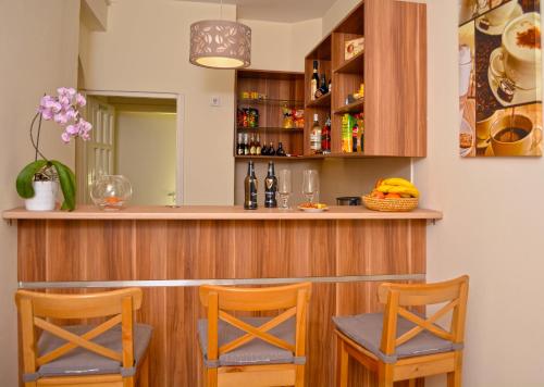 un bar con due sedie e un bancone con bottiglie di Airport Glossel Panzió a Vecsés
