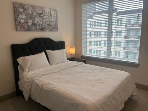 a bedroom with a large bed with a large window at Resort-Style Apartments near The Galleria in Houston