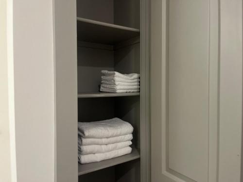 un armario con toallas blancas en un estante en Resort-Style Apartments near The Galleria, en Houston