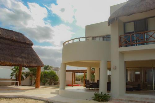a large white building with a thatched roof at Villa Karpatos in Progreso