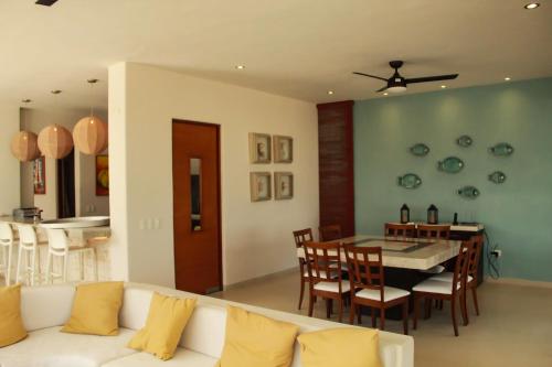 a living room with a white couch and a dining room at Villa Karpatos in Progreso