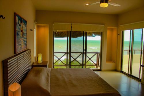 a bedroom with a bed and a view of the ocean at Villa Karpatos in Progreso