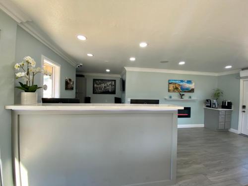 a large room with a white counter and a living room at Aura Inn Monterey in Monterey