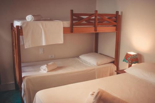Pousada Hannah في برادو: غرفة نوم بسريرين بطابقين مع مناشف عليها