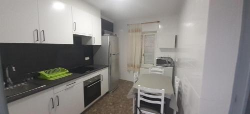 eine kleine Küche mit weißen Schränken und einer Spüle in der Unterkunft PLANTA BAJA EN SANTA POLA in Santa Pola