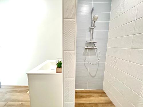 La salle de bains est pourvue d'une douche et d'une baignoire blanche. dans l'établissement La havane, paisible gîte à 5 min du Futuroscope, à Saint-Georges-lès-Baillargeaux