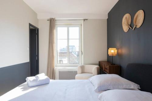 1 dormitorio con 1 cama, 1 silla y 1 ventana en La cour Liebault, en Nancy