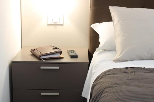 a bed with a night stand with a phone on it at PIUMABLU in Campi Bisenzio