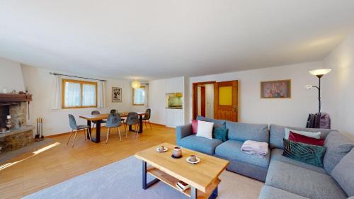 a living room with a blue couch and a table at Abitaziun Cuntainta 1 - Champfèr in Champfer