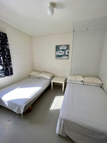 a room with two beds and a table in it at Trolltunga Studios in Odda
