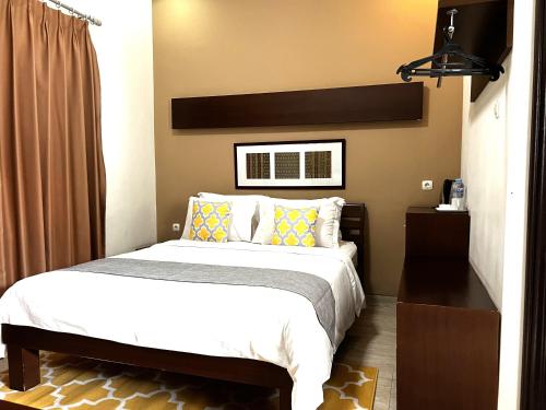 a bedroom with a large bed and a window at Avila Ketapan Rame Hotel in Trawas