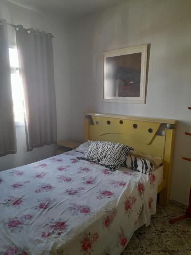 um quarto com uma cama com colcha floral em Ap 300m praia do morro em Guarapari